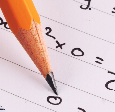 Student using pencil to write down algebra equation