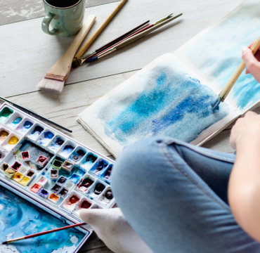 Female student using a watercolour brush to paint