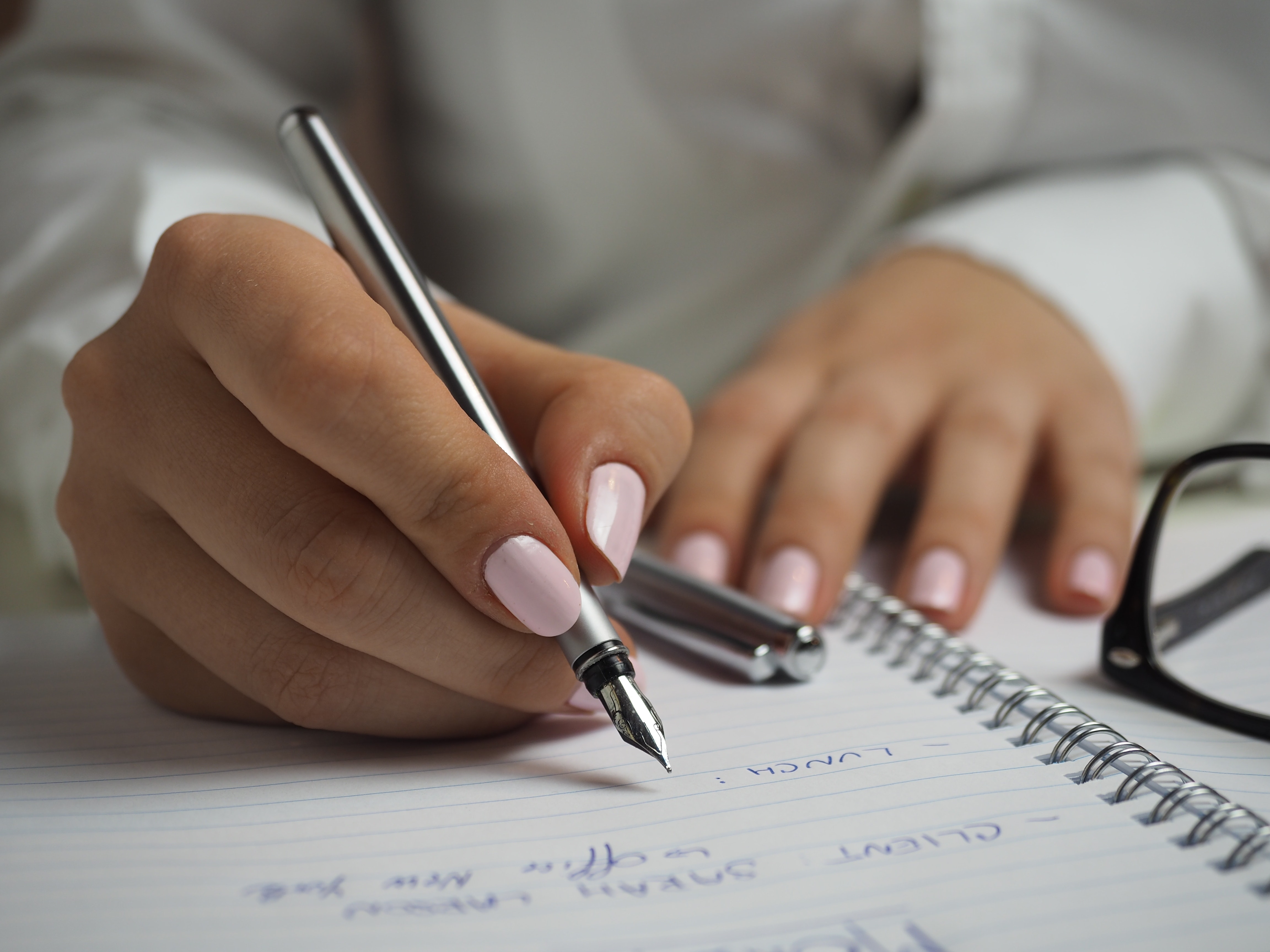 Woman making notes with a silver pen