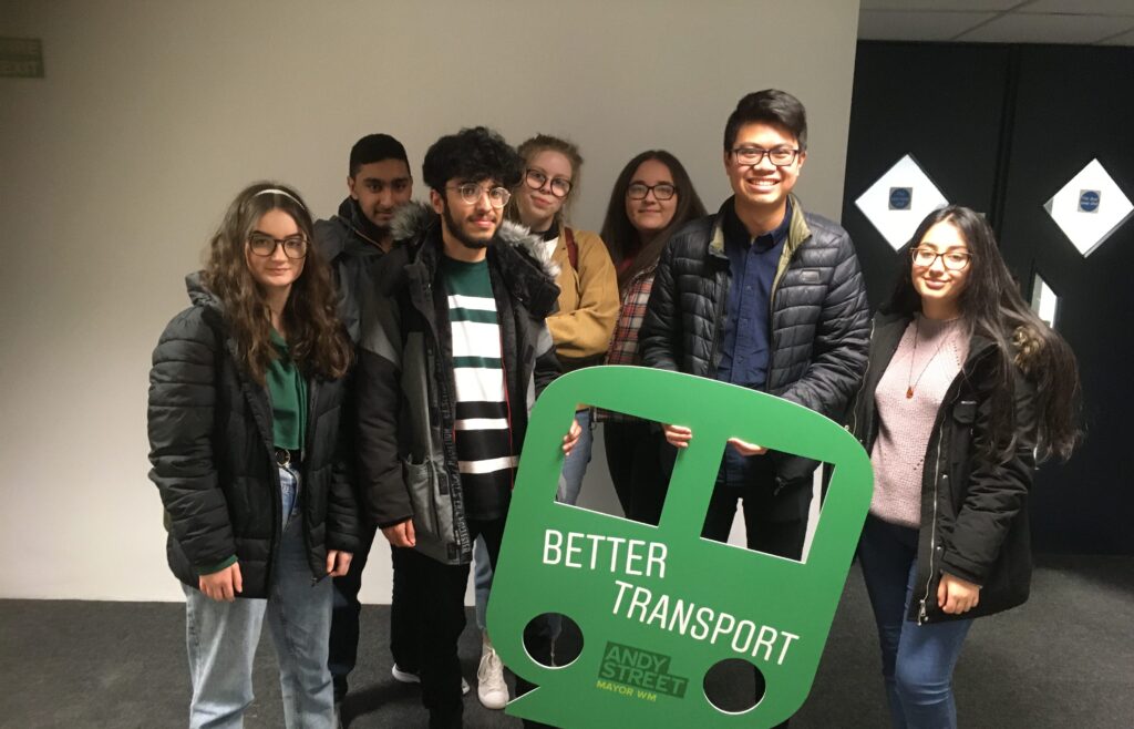 Group of Central Saint Michael's Sixth Form students holding a cardboard promotional banner