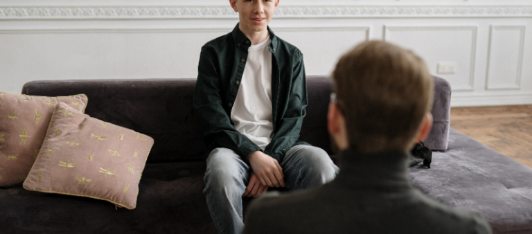 Young male speaking to Psychologist in his office