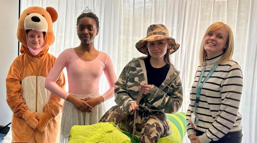 Drama students dressed in dragon, teddy and ballerina costumes