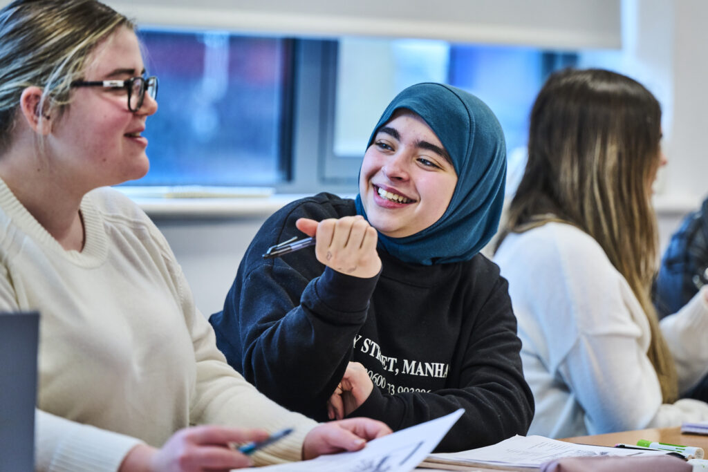 Two girls laughing in classroom