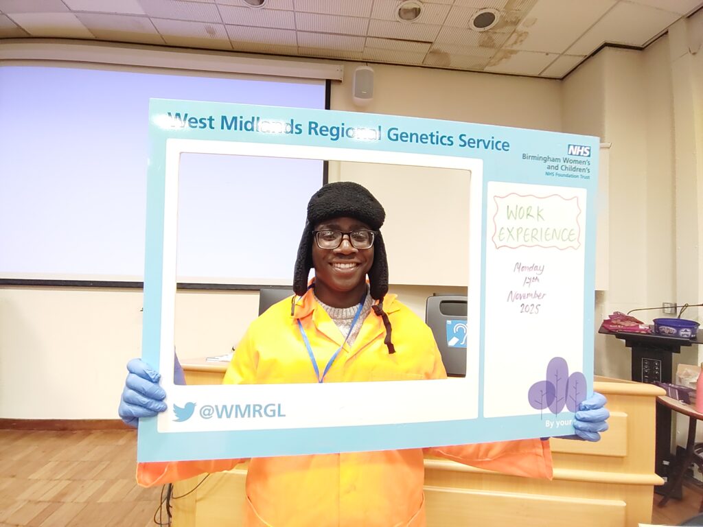 A Level Maths student Chris holding West Mids Regional Genetics Service frame