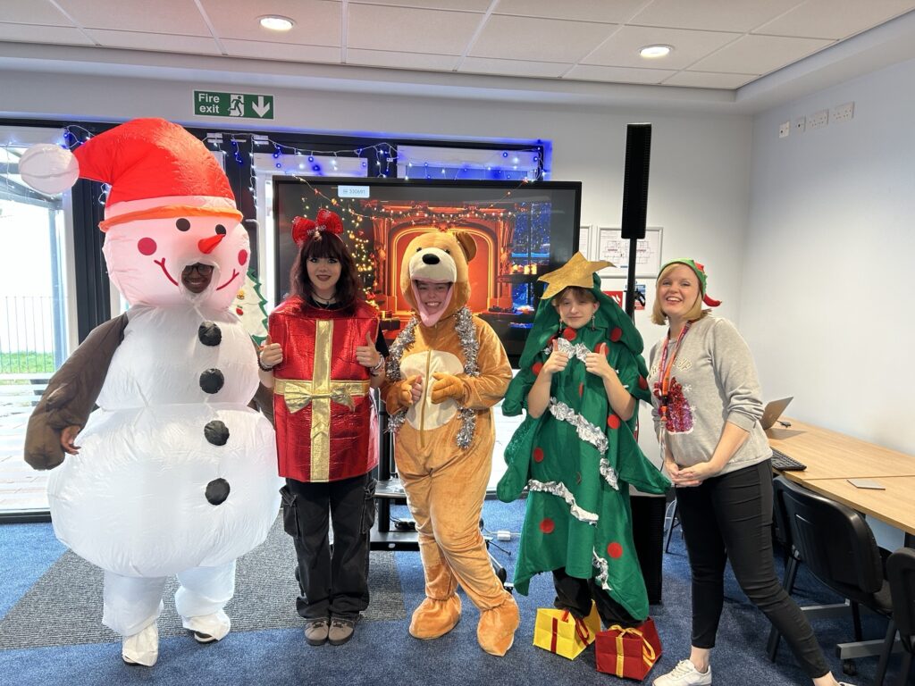 Four students and lecturer dressed in Christmas costumes
