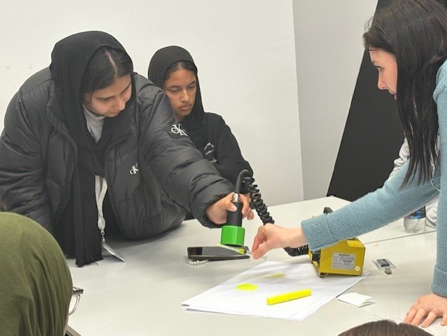 Science teacher demonstrating a medical physics tracer to students