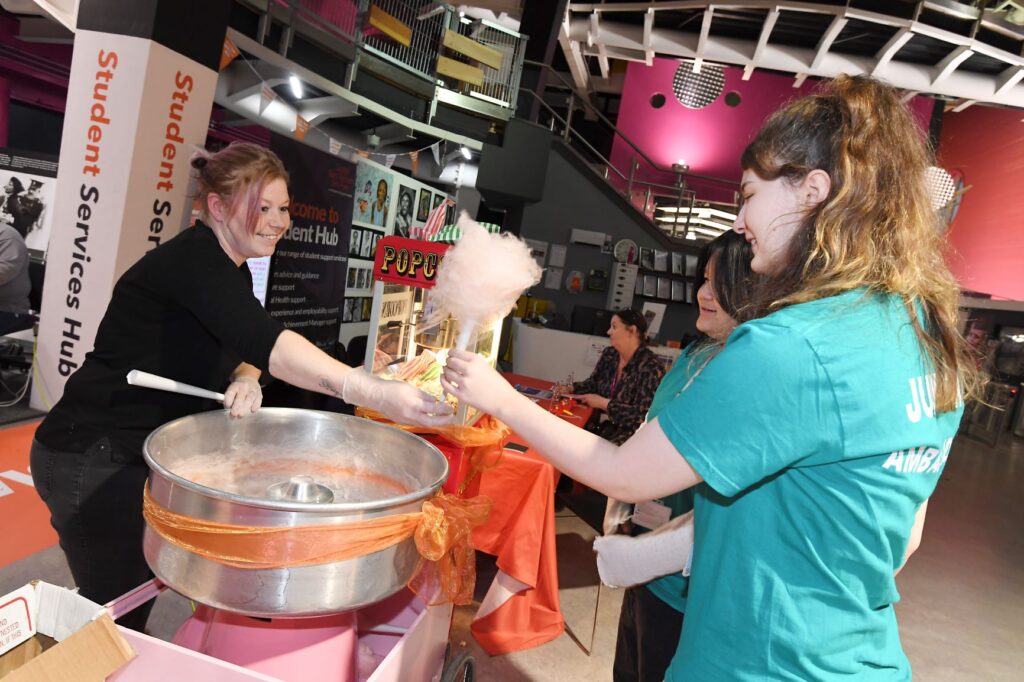 Student ambassadors are served with candy floss at open day